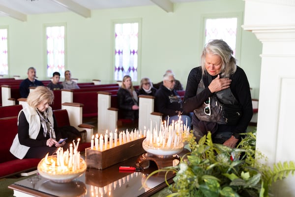 Mugsy Reynolds becomes emotional after lighting a candle in honor of former President Jimmy Carter at a vigil at Maranatha Baptist Church in Plains on Saturday, January 4, 2025, after a motorcade including a hearse carrying Carter’s casket went through town. The motorcade then headed to Atlanta where Carter will lie in repose at the Carter Presidential Center. (Arvin Temkar / AJC)