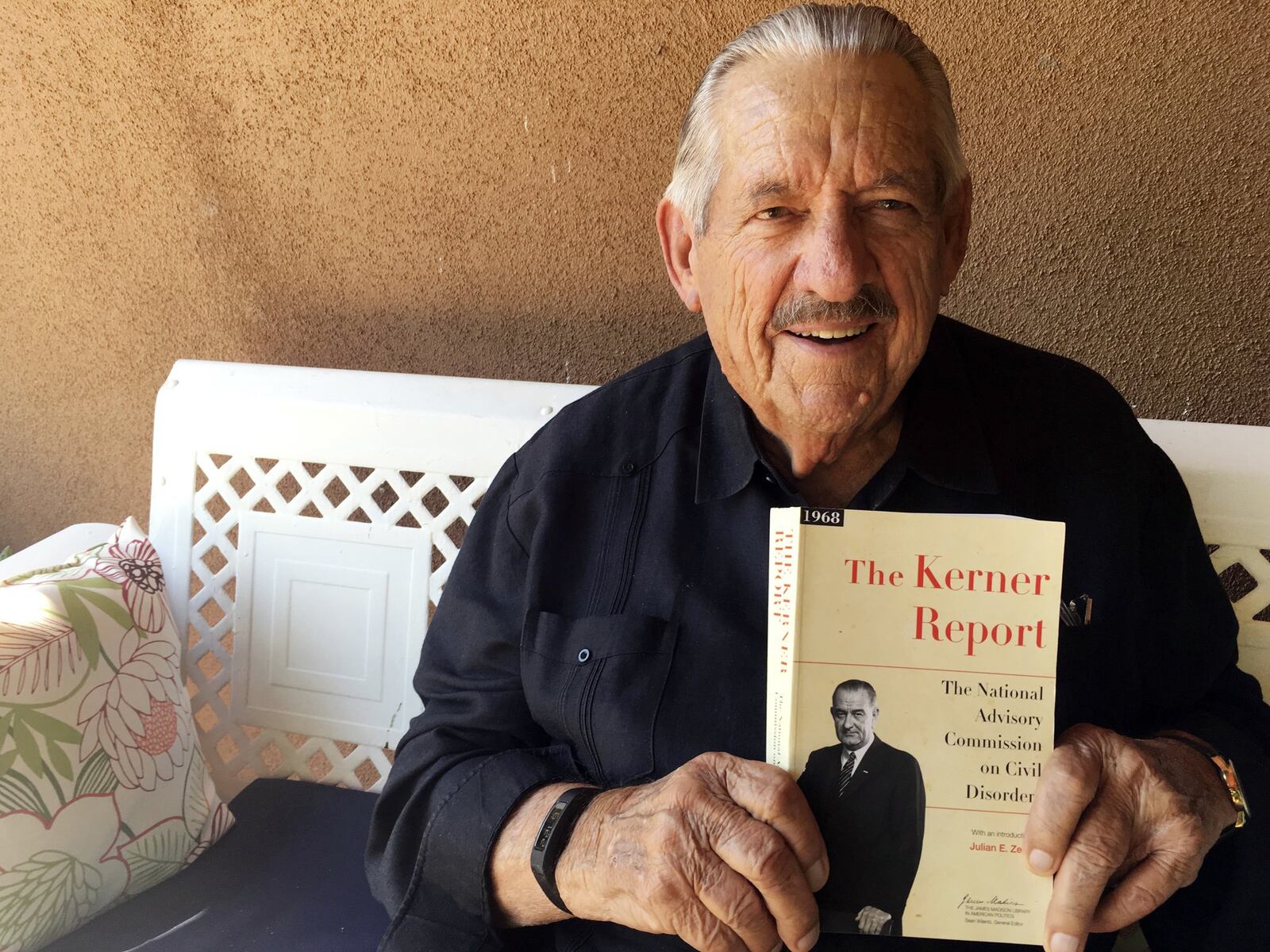 In this Aug. 31, 2017, photo, former U.S. Sen. Fred Harris of Oklahoma holds a copy of “The Kerner Report” at his home in Corrales, N.M., as he discusses the 50th anniversary of the Kerner Commission, a panel appointed by President Lyndon Johnson in 1967 to examine the causes of the 1960s riots. Harris is the last surviving member of the Kerner Commission, and he says he remains haunted that its recommendations on U.S. race relations and poverty were never adopted. AP PHOTO / RUSSELL CONTRERAS