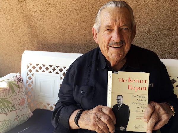 In this Aug. 31, 2017, photo, former U.S. Sen. Fred Harris of Oklahoma holds a copy of “The Kerner Report” at his home in Corrales, N.M., as he discusses the 50th anniversary of the Kerner Commission, a panel appointed by President Lyndon Johnson in 1967 to examine the causes of the 1960s riots. Harris is the last surviving member of the Kerner Commission, and he says he remains haunted that its recommendations on U.S. race relations and poverty were never adopted. AP PHOTO / RUSSELL CONTRERAS