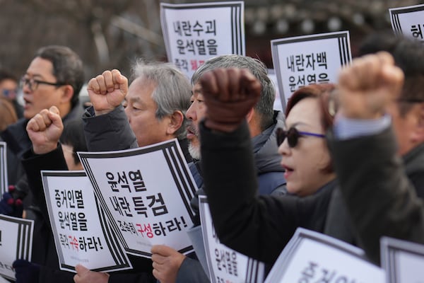 Members of civic groups shout slogans during a news conference demanding the arrest of President Yoon Suk Yeol near the presidential residence in Seoul, South Korea, Tuesday, Dec. 17, 2024. The letters read "Immediately arrest Yoon Suk Yeol." (AP Photo/Lee Jin-man)