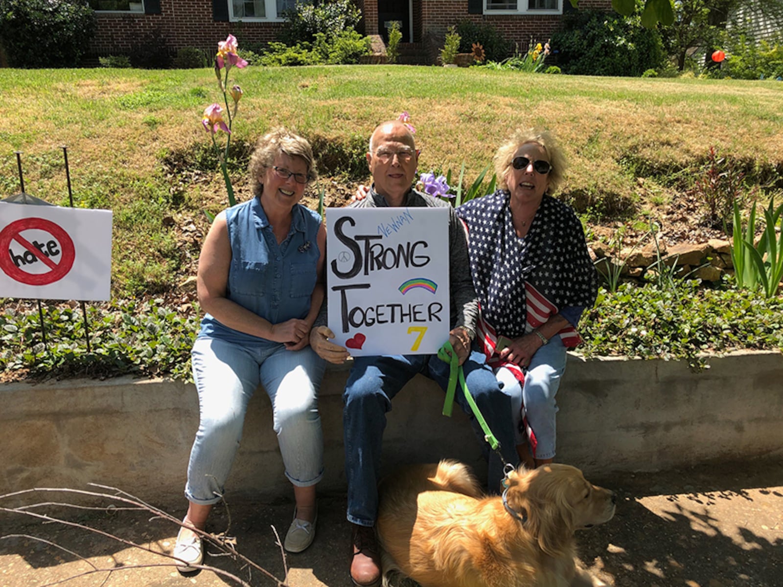 Newnan residents (from left) Jenny Lewis, Jack McBride and Chris McBride show their anti-hate signs ahead of Saturday’s planned rally by neo-Nazis.