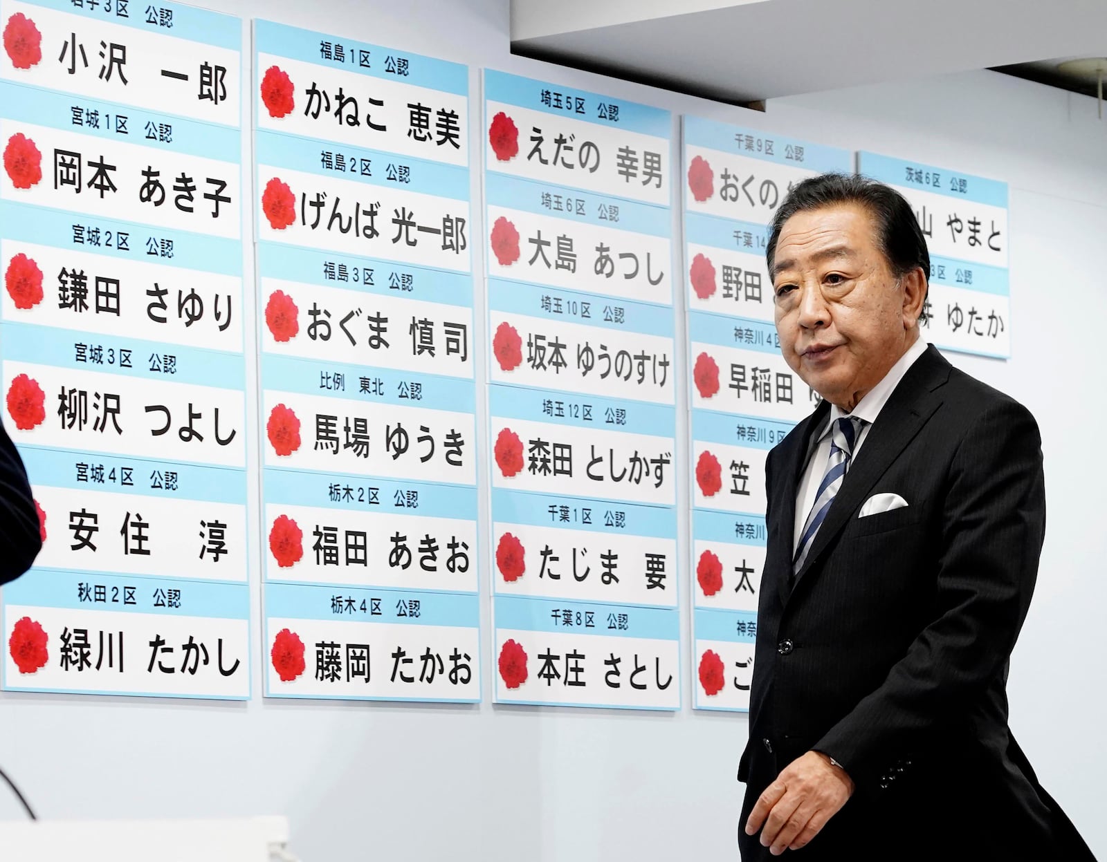 Yoshihiko Noda, leader of Japan's opposition Constitutional Democratic Party, prepares for a media while the board shows the names of the party's candidates who won the lower house election, at the party's headquarters Sunday, Oct. 27, 2024 in Tokyo, (Kyodo News via AP)