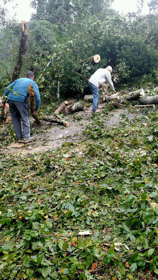 Zac Raby (left) and Stephen Perras make their way around the Medlock Park neighborhood Monday clearing branches from roofs, streets and driveways. (Photo by Kristin Kelly Mayfield)