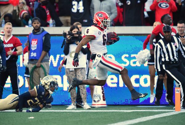 Georgia's running back Kenny McIntosh (6) runs past Georgia Tech's defensive back Miles Brooks (20) for a touchdown during the second half of an NCAA college football game at Georgia Tech's Bobby Dodd Stadium in Atlanta on Saturday, November 27, 2021. Georgia won 45-0 over Georgia Tech. (Hyosub Shin / Hyosub.Shin@ajc.com)