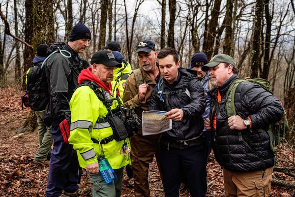 A search party led by Gilmore County search and rescue looked over a map to determine where they needed to be to accomplish their search pattern.