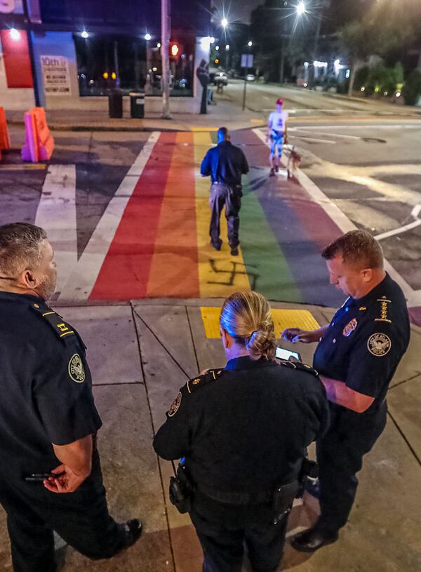 Interim Atlanta police Chief Darin Schierbaum (right) stands with officers at the rainbow crosswalk at 10th Street and Piedmont Avenue after it was vandalized again Friday morning. Schierbaum said police are investigating the act as a hate crime.