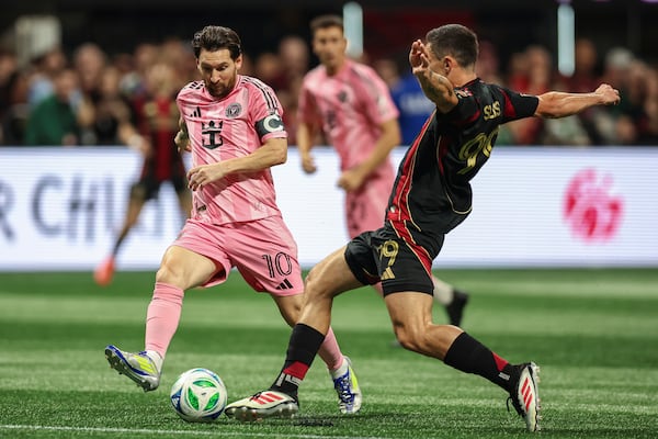 Inter Miami forward Lionel Messi (10) fights for the ball against Atlanta United midfielder Bartosz Slisz, right, during the first half of an MLS soccer match Sunday, March, 16, 2025, in Atlanta. (AP Photo/Colin Hubbard)