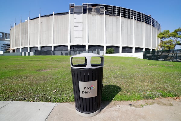 A trashcan sits on the sidewalk outside of the now dormant Astrodome, part of NRG Park, Wednesday, Nov. 13, 2024, in Houston. The Astrodome Conservancy, a group dedicated to preserving the structure, has proposed a multi-use renovation for the once legendary building. (AP Photo/Michael Wyke)