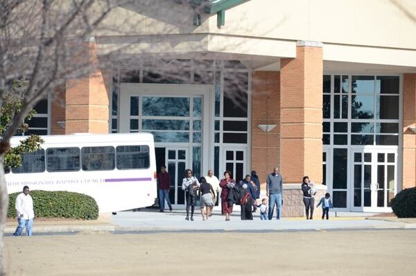 Parishioners leave the New Birth Missionary Baptist Church Sunday morning. KENT JOHNSON/ KENT.JOHNSON@AJC.COM