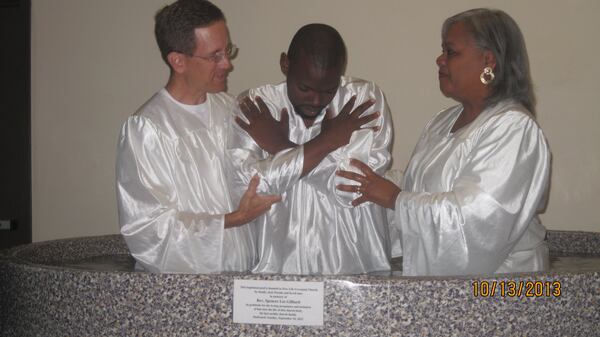 Co-pastors Tim Rodgers and Catherine Gilliard prepare to baptize a member at New Life Covenant Church. They believe the church should play a role in healing the racial divide in our nation. Contributed