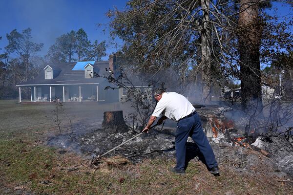 David Livingston burns piles of stumps and debris in the aftermath of Hurricane Helene in Hazlehurst, Ga. Livingston’s house had roof damages, some fallen trees and no power for 17 days. (Hyosub Shin/AJC)