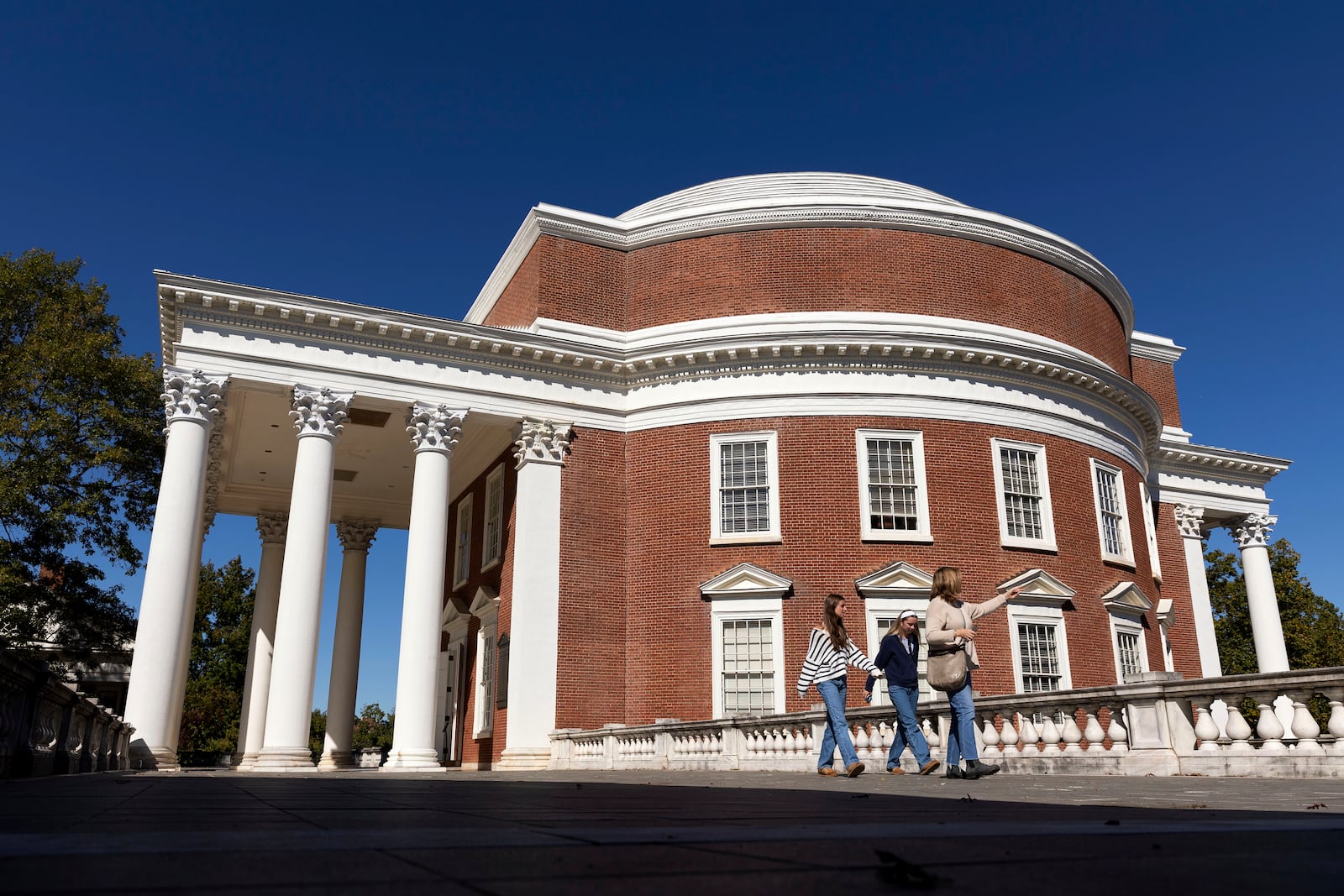 People walk past the Rotunda at the University of Virginia in Charlottesville, Va., Friday, Oct. 11, 2024. (AP Photo/Ryan M. Kelly)