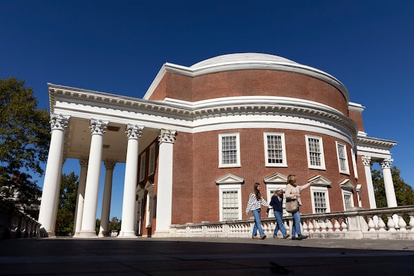 People walk past the Rotunda at the University of Virginia in Charlottesville, Va., Friday, Oct. 11, 2024. (AP Photo/Ryan M. Kelly)