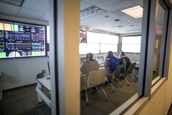 Systems engineers Jerry Thomas, 63, Corey English, 42, and Andy Clement, 47, monitor screens for  the DeKalb County School District. (CASEY SYKES, CASEY.SYKES@AJC.COM)