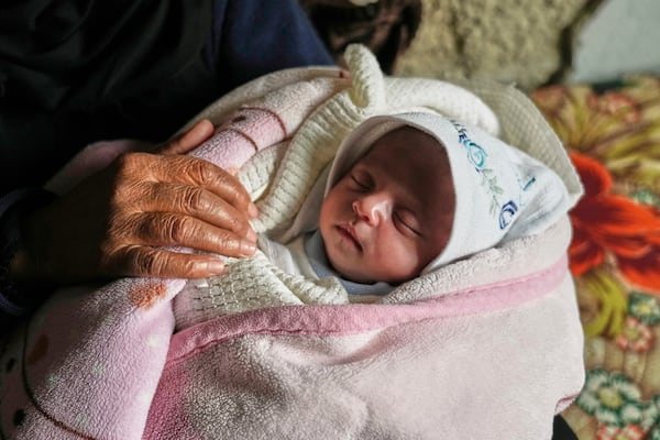 Ella Osama Abu Dagga, 25 days old, is held by her great-aunt Suad Abu Dagga after she was pulled from the rubble earlier following an Israeli army airstrike that killed her parents and brother in Khan Younis, southern Gaza Strip, Thursday, March 20, 2025. (AP Photo/Abdel Kareem Hana )