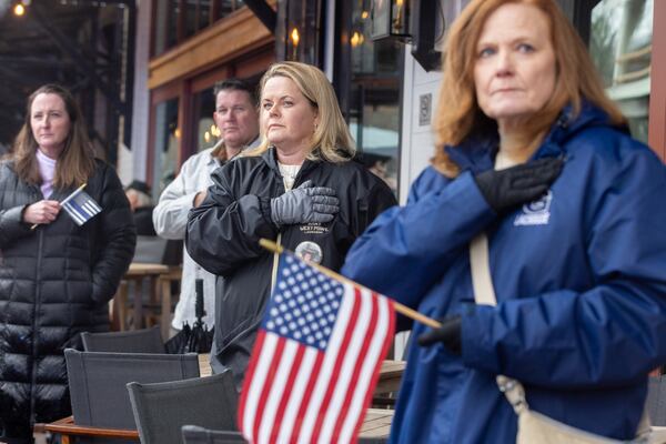 Mourners watch as a funeral procession for fallen police officer Jeremy Labonte drives through downtown Roswell on Wednesday, February 12, 2025. The 24-year-old Roswell Police Department officer was shot to death on Friday evening. (Arvin Temkar / AJC)