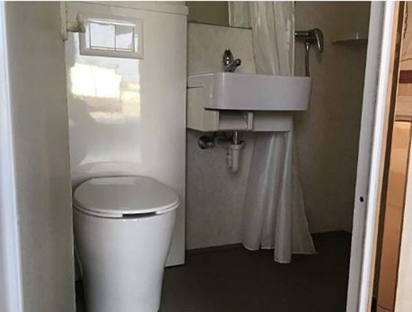 The bathroom includes a toilet, sink and shower.