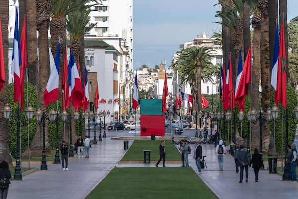 People walk past Moroccan and French flags on Mohammed V avenue ahead of French president Emmanuel Macron official visit to Morocco, in the capital Rabat, Monday, Oct. 28, 2024. (AP Photo/Mosa'ab Elshamy)