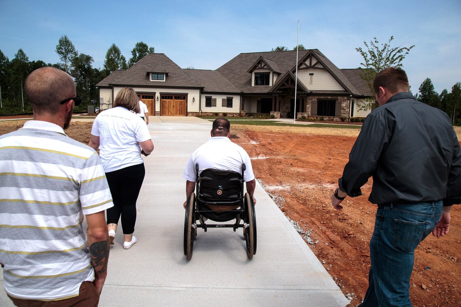 Retired Cpl. Sean Adams, a Marine who lost both legs in the war in Afghanistan in 2012, heads toward his new specially adapted smart home in Maysville on May 19, 2017. The house was built and donated to Adams through the Gary Sinise Foundation. STEVE SCHAEFER / SPECIAL TO THE AJC