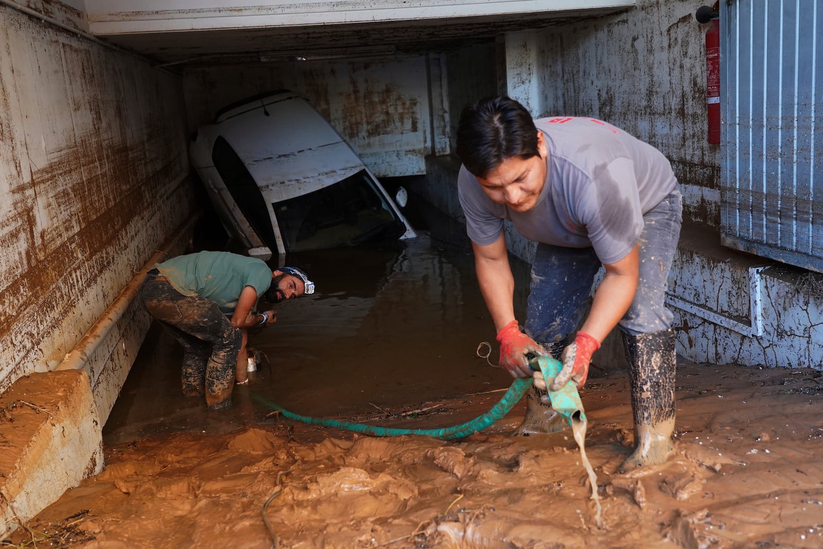 Residents clean their house affected by floods in Valencia, Spain, Thursday, Oct. 31, 2024. (AP Photo/Alberto Saiz)