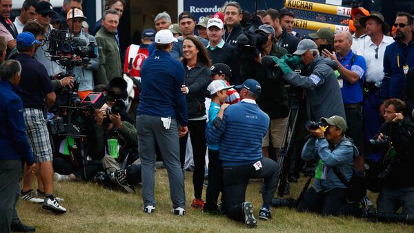 Jordan Spieth (left) greets Matt Kuchar's wife, Sybi, and children on the 18th green.