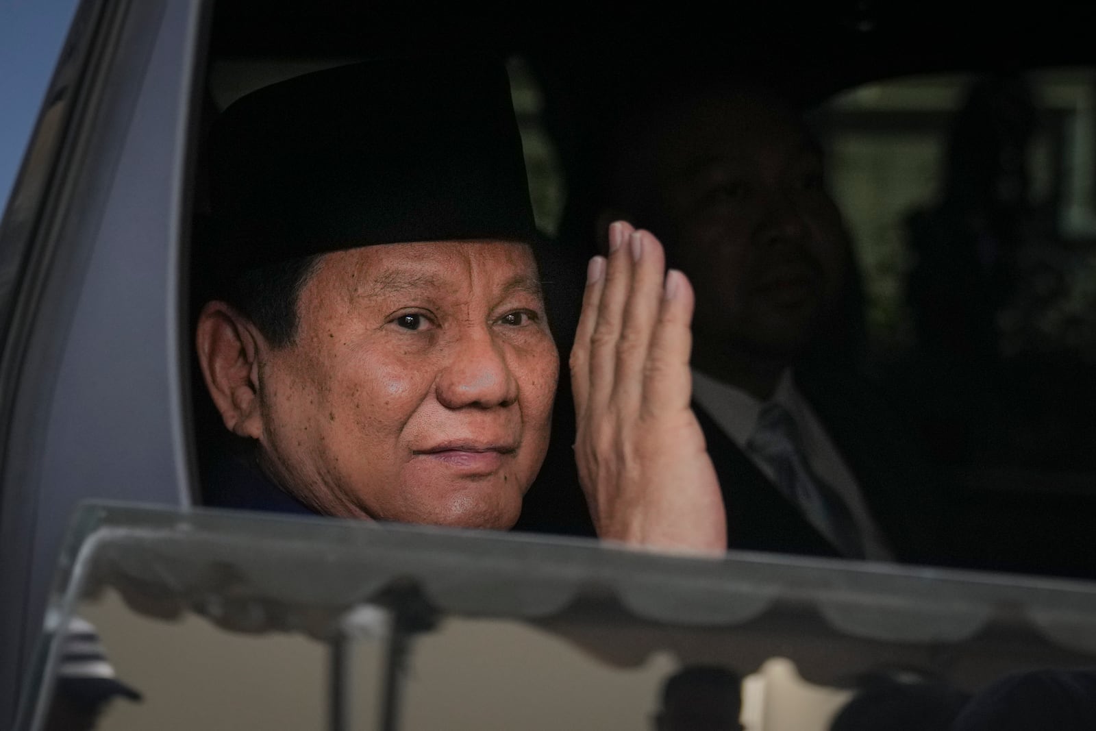 Indonesian president-elect Prabowo Subianto, waves to media as he leave for inauguration ceremony in Jakarta, Indonesia, Sunday, Oct. 20, 2024. (AP Photo/Dita Alangkara)