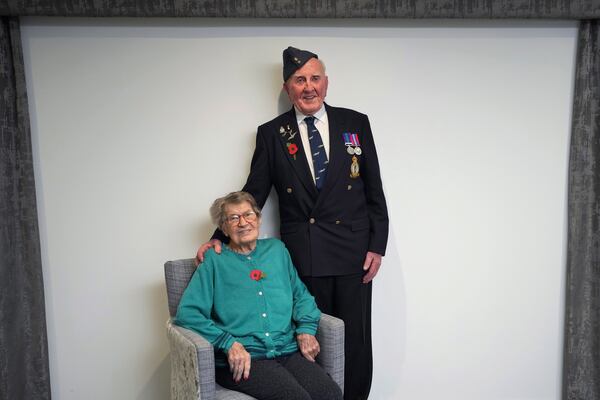 Michael Woods, 100-year-old World War II veteran, poses with his wife Mary during an interview in Dunstable, Bedfordshire, England, Tuesday, Nov. 5, 2024. (AP Photo/Kin Cheung)