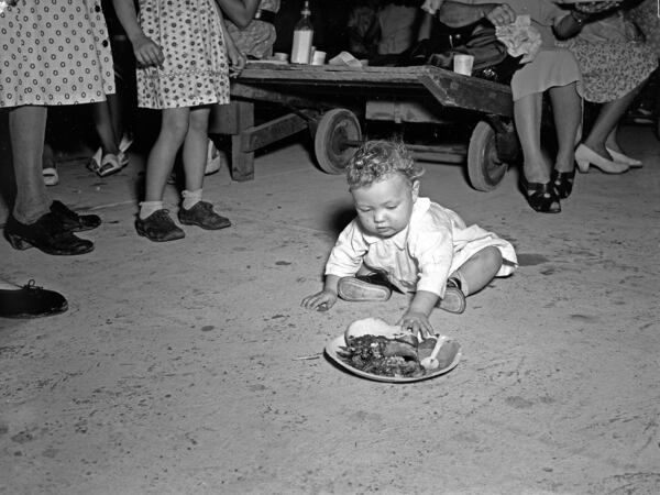 The Atlanta History Center exhibition “Barbecue Nation” explores the appeal of barbecue through American history and artifacts, including this 1940s photograph of a tobacco warehouse opening in Florida. CONTRIBUTED BY ATLANTA HISTORY CENTER