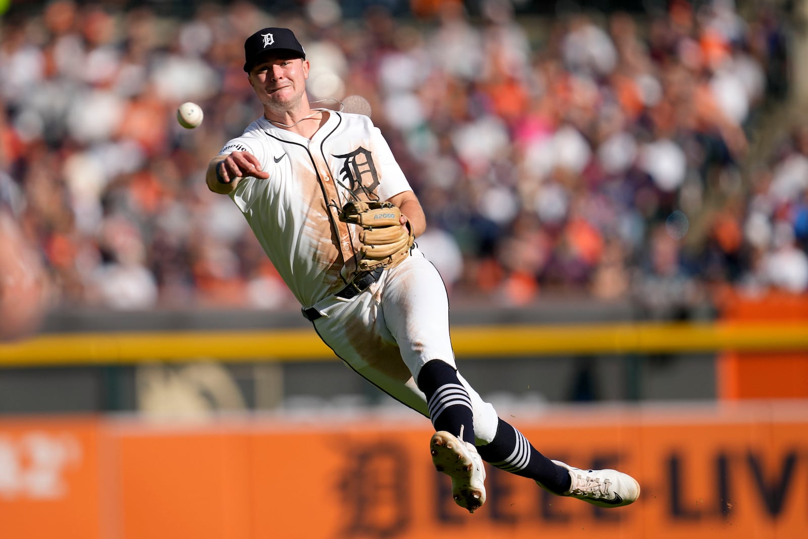 Detroit Tigers shortstop Trey Sweeney throws errantly to first base on a single by Cleveland Guardians' Steven Kwan in the third inning during Game 3 of a baseball American League Division Series, Wednesday, Oct. 9, 2024, in Detroit. (AP Photo/Paul Sancya)