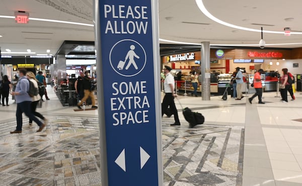 Travelers wearing face masks make their way at Hartsfield-Jackson International Airport on Thursday, July 2, 2020.  (Hyosub Shin / Hyosub.Shin@ajc.com)