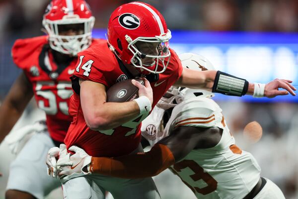 Georgia quarterback Gunner Stockton (14) runs for yards during the third quarter against Texas during the 2024 SEC Championship game at Mercedes-Benz Stadium, Saturday, December 7, 2024, in Atlanta. Georgia won 22-19 in overtime. Jason Getz / AJC)
