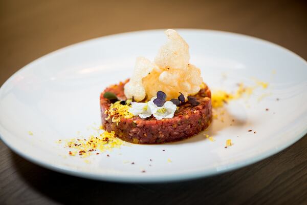  Beef Tartare with cured egg yolk, preserved yuzu, korean chili, shallot, smoked salt, and rice puff. Photo credit- Mia Yakel.