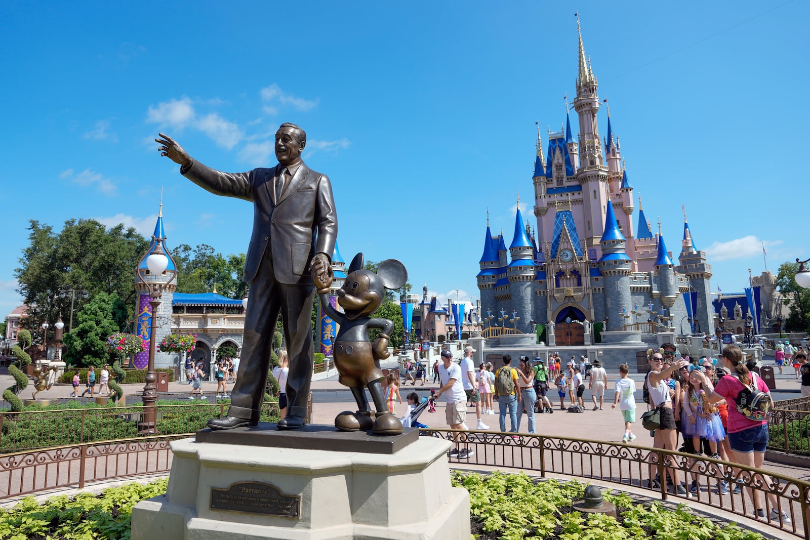 FILE - Guests pass a statue of Walt Disney and Mickey Mouse in the Magic Kingdom at Walt Disney World on July 14, 2023, in Lake Buena Vista, Fla. (AP Photo/John Raoux, File)