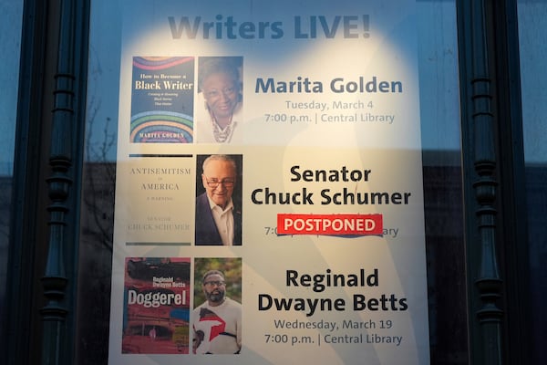 A sign announcing that Senate Democratic Leader Chuck Schumer's scheduled book tour event was postponed is seen in a window of the Central Library branch of the Enoch Pratt Free Library in Baltimore, Monday, March 17, 2025. (AP Photo/Stephanie Scarbrough)