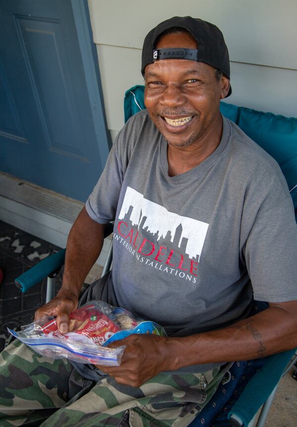 Jesse Thomas is all smiles after receiving a "grace bag" from Malachi Project volunteers as they serve neighbors in the McDonough Housing Authority Complex. PHIL SKINNER/ FOR THE AJC