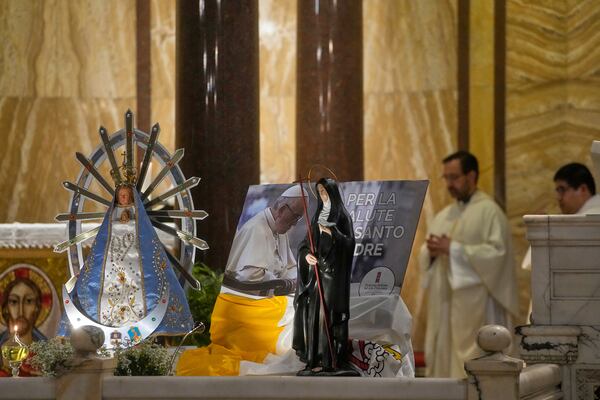 A picture of Pope Francis is displayed near a stauette of Our Lady of Lujan, left, during a thanksgiving mass on the 12th anniversary of Pontiff's election at the Argentinean's church in Rome, Thursday, March 13, 2025. (AP Photo/Gregorio Borgia)