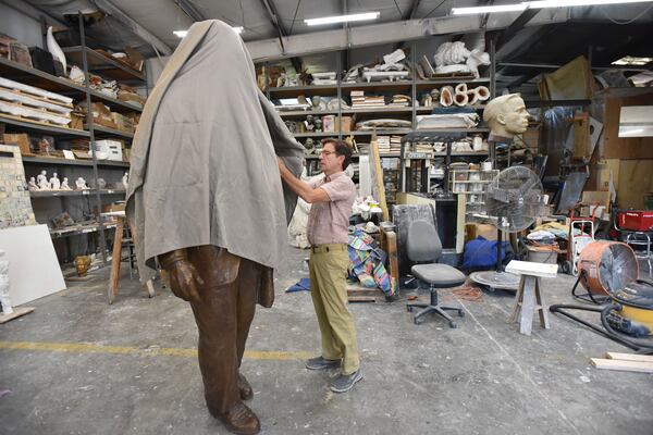 Dawe covers the King statue that will be unveiled on Monday. HYOSUB SHIN / HSHIN@AJC.COM