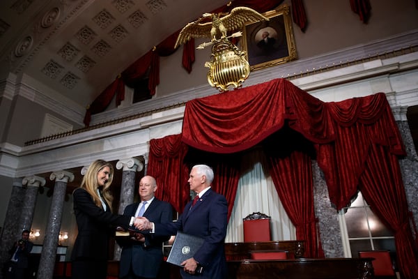 Sen. Kelly Loeffler, R-Ga., left, with her husband Jeffrey Sprecher, center, shakes hands with Vice President Mike Pence after a re-enactment of her swearing-in Monday, Jan. 6, 2020, in the Old Senate Chamber on Capitol Hill in Washington. (AP Photo/Jacquelyn Martin)