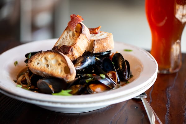 The Lost Druid Drunken Mussels, mussels bathed in a smoked pork beer broth with soy, shallots, scallions, and lime with toasted baguette slices.