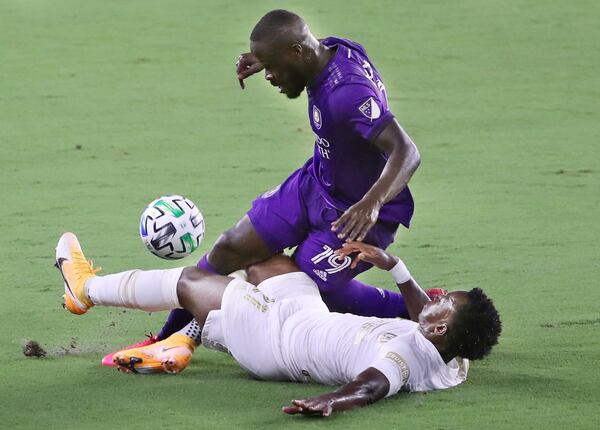 Atlanta United's George Bello, bottom, stops a drive at goal by Orlando City's Benji Michel, top, at Exploria Stadium in Orlando, Florida, on Saturday, Sept. 5, 2020. (Stephen M. Dowell/Orlando Sentinel/TNS)