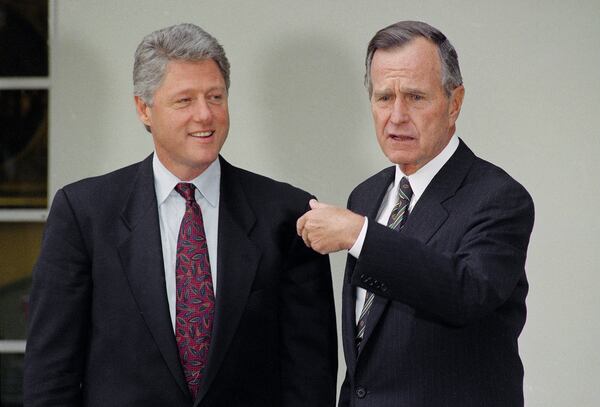 FILE - President George H.W. Bush gestures toward President-elect Bill Clinton at the White House, Nov. 18, 1992, in Washington. (AP Photo/Barry Thumma, File)