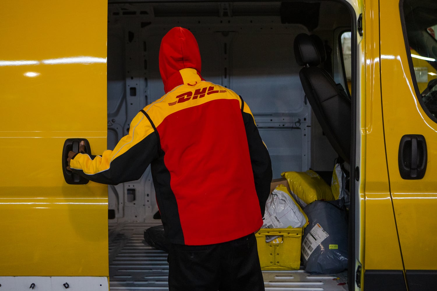 A DHL employee loads packages into a van on Wednesday, December 16, 2020, at DHL Express in Atlanta. Workers at the shipping center worked to fulfill orders during the holiday rush. CHRISTINA MATACOTTA FOR THE ATLANTA JOURNAL-CONSTITUTION.