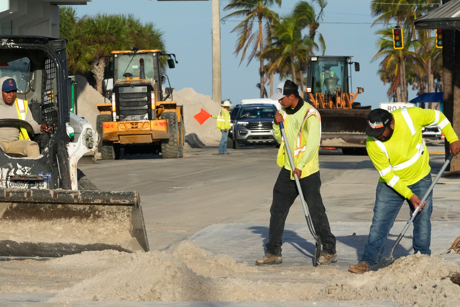 Public work employees remove sand from the roadways, that was pushed to the streets by Hurricane Milton, Friday, Oct. 11, 2024, in Fort Myers Beach, Fla. (AP Photo/Marta Lavandier)