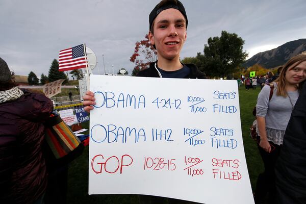 Julian Dreiman of Boulder, Colo., holds up sign in the free speech zone on the campus of the University of Colorado before the Republican presidential debate Wednesday, Oct. 28, 2015, in Boulder, Colo. Several protests were being staged across the campus as Republican candidates faced off in the Coors Events Center. (AP Photo/David Zalubowski)