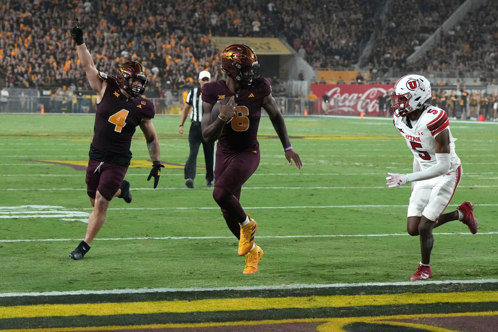 Arizona State quarterback Jeff Sims scores a touch down while getting escorted by running back Cam Skattebo (4) in front of Utah cornerback Zemaiah Vaughn in the first half during an NCAA college football game, Friday, Oct. 11, 2024, in Tempe, Ariz. (AP Photo/Rick Scuteri)