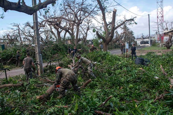 This photo provided Sunday Dec.15, 2024 by the French Army shows soldiers removing fallen trees in the French territory of Mayotte in the Indian Ocean, after Cyclone Chido caused extensive damage with reports of several fatalities. (Etat Major des Armées via AP)