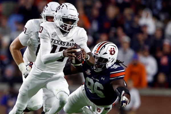 Texas A&M quarterback Marcel Reed (10) is tackled by Auburn defensive lineman Philip Blidi (96) as he scrambles for yardage during the first half of an NCAA college football game, Saturday, Nov. 23, 2024, in Auburn, Ala. (AP Photo/Butch Dill)