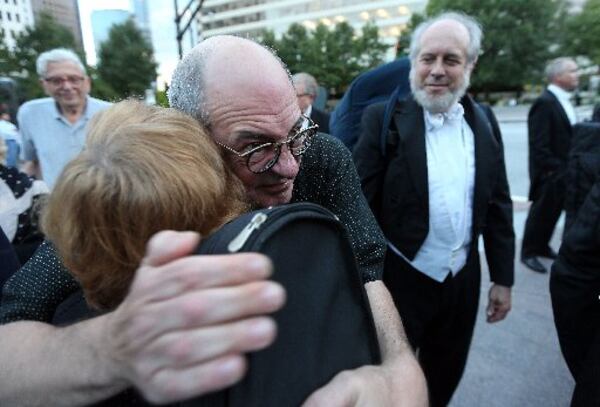 A YEAR AGO: Atlanta Symphony Orchestra Music Director Robert Spano hugs violinist Ruth Ann Little as he greets musicians on Sept. 24, 2014 prior to a a protest over the musician lockout. Musicians silently gathered in Callaway Plaza at the Woodruff Arts Center as supporters, including Spano, applauded. BEN GRAY / BGRAY@AJC.COM