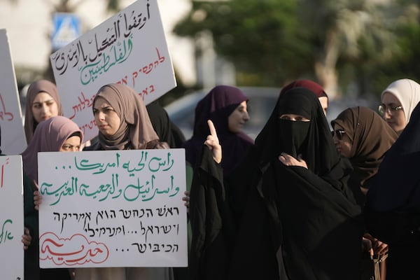 Palestinian citizens of Israel protest against Israel's military operations in the Gaza Strip and Lebanon, in Umm Al-Fahm, Israel, Saturday, Nov. 9, 2024. The placard in Arabic reads: "the head of the snake is America, Israel and Arab reactionaries." (AP Photo/Mahmoud Illean)