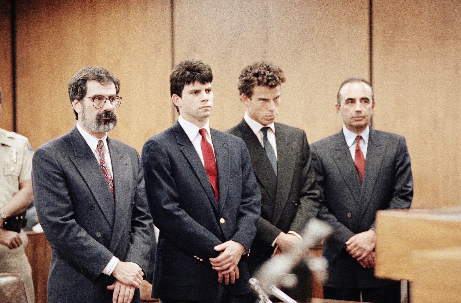 FILE - Lyle Menendez, second from left, and his brother, Erik, second from right, are flanked by their attorneys Gerald Chaleff, left, and Robert Shapiro, as the brothers delayed entering pleas through their attorneys in Beverly Hills Municipal Court, March 13, 1990. (AP Photo/Nick Ut, File)